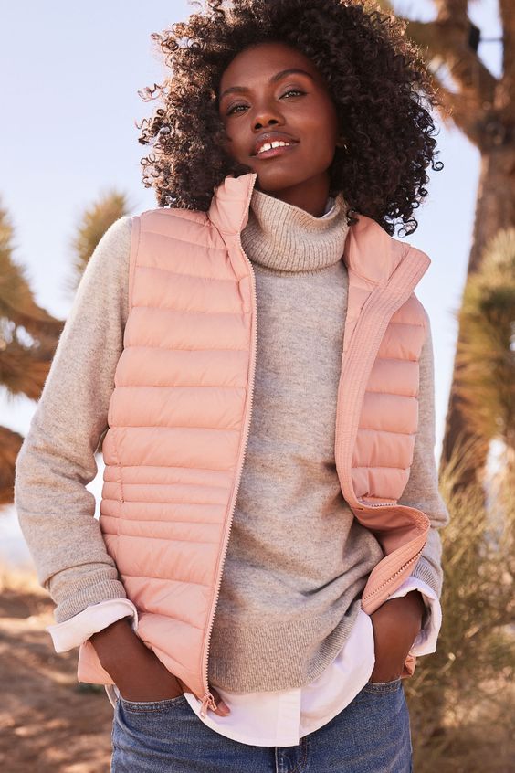 Lands End US and UK.  Lightweight fleece sleeveless vest or gilet in peach worn with shirt and jeans