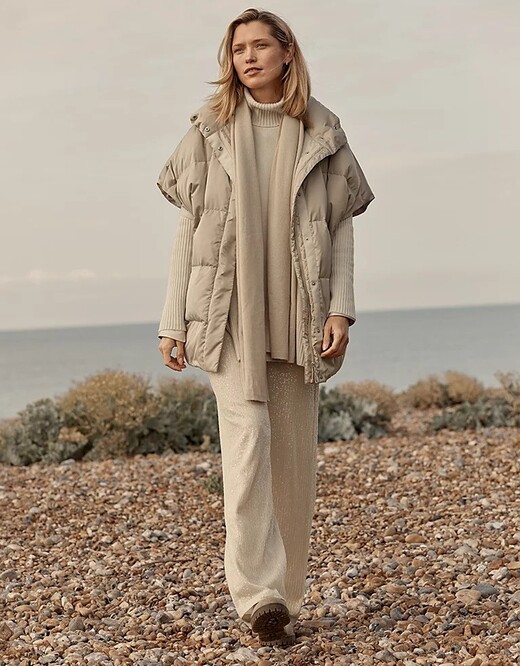 A beige toned outfit for winter with a cream gilet by The White Company over wide beige pants